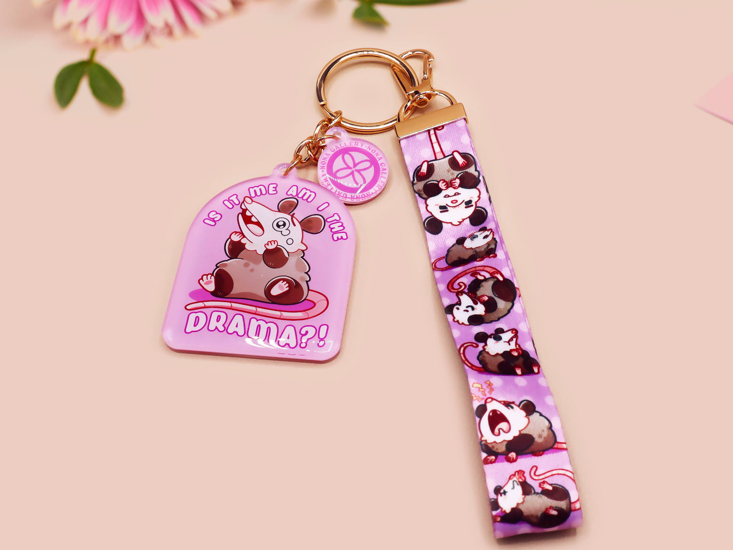 Acrylic epoxy possum keychain with a large acrylic charm of a purple screaming possum with the quote is it me am I the drama, a smaller charm of a cute crying possum and a matching purple possum lanyard.
