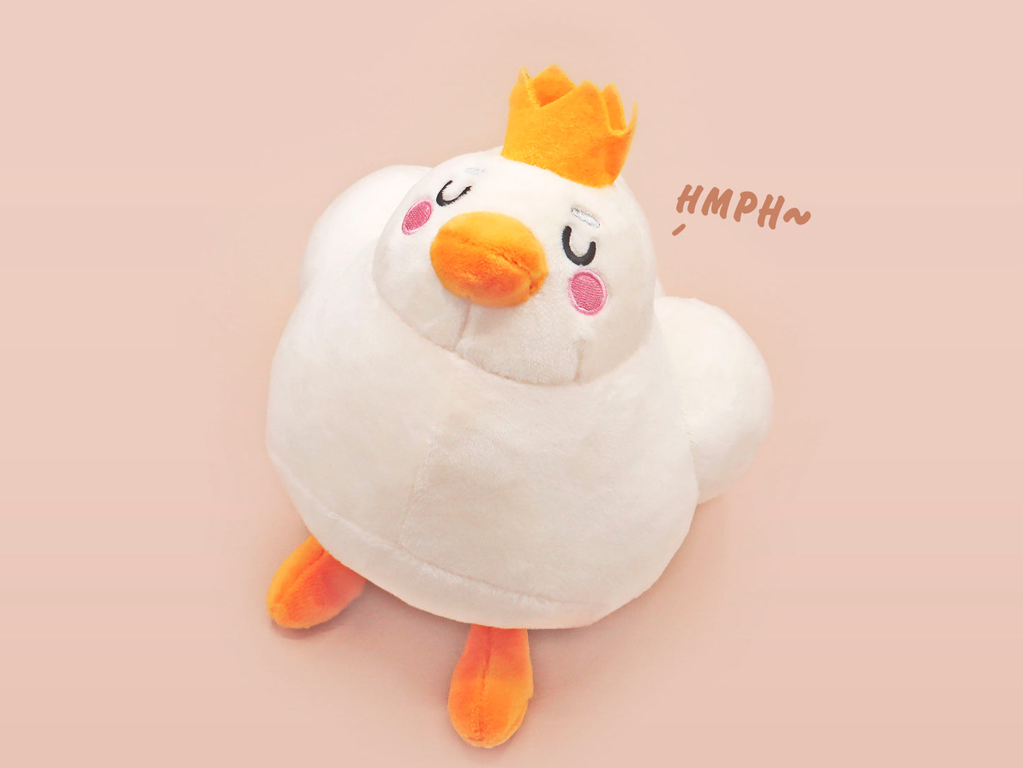 An adorable white duck bird plushie toy with cute embroidered eyes and facial expression, wearing a yellow crown hat, with a hang tag describing the duck as King Larry.