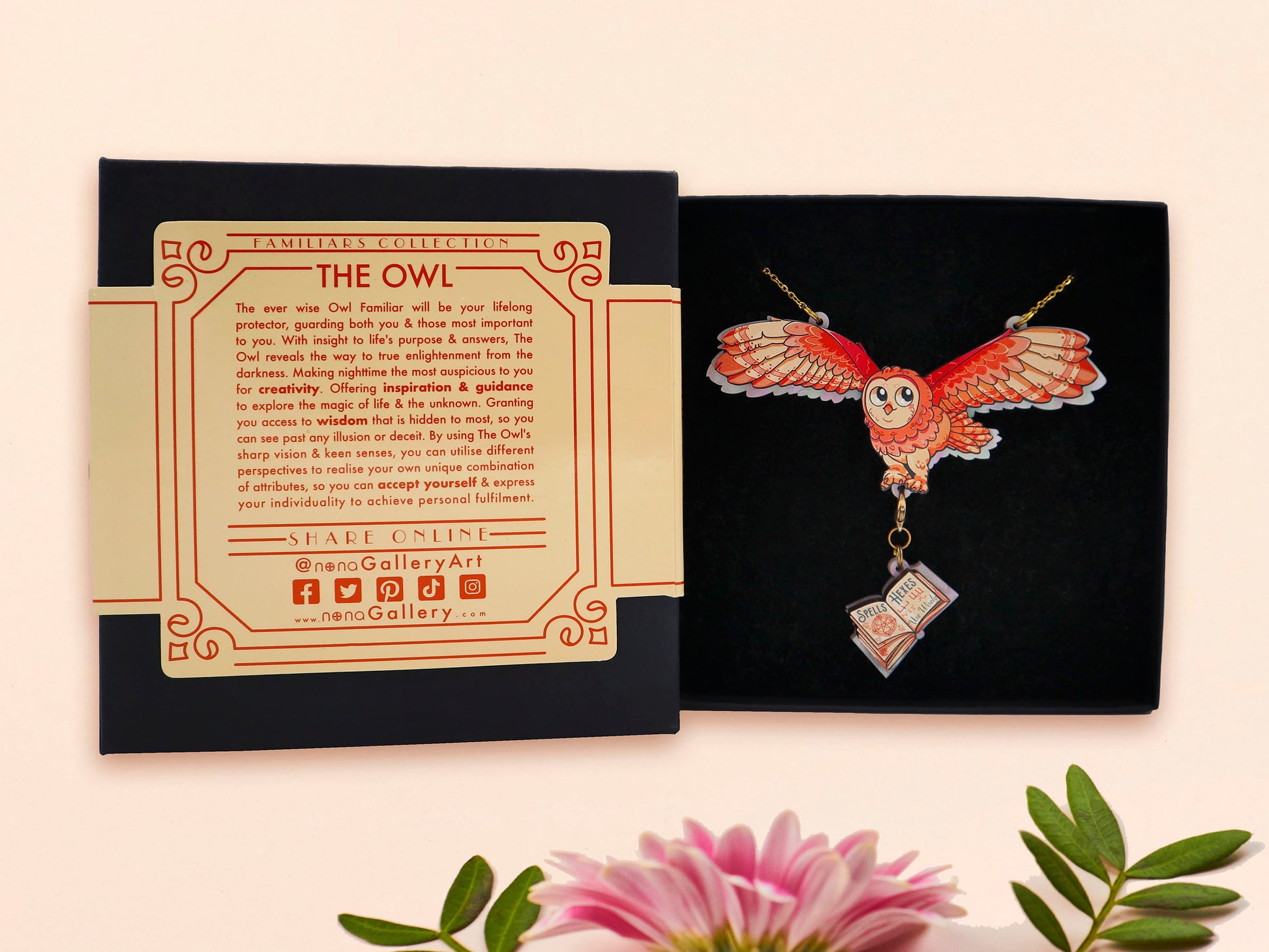 Mixed material handmade necklace of chibi cartoon flying barn owl with pearlescent wings carrying a removeable spell book charm, with a gold chain and black gift box with a yellow familiars collection gift sleeve.
