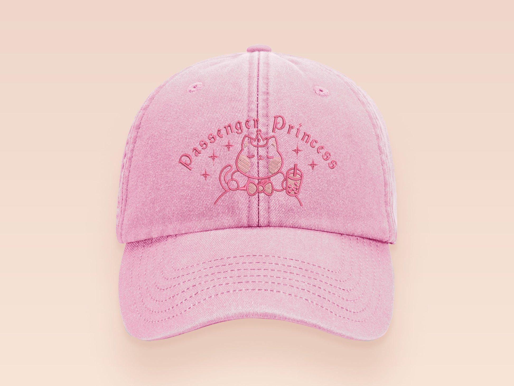A vintage pink baseball cap hat with an embroidered cute princess cat wearing a seatbelt and holding a boba bubble tea drink with the quote Passenger Princess