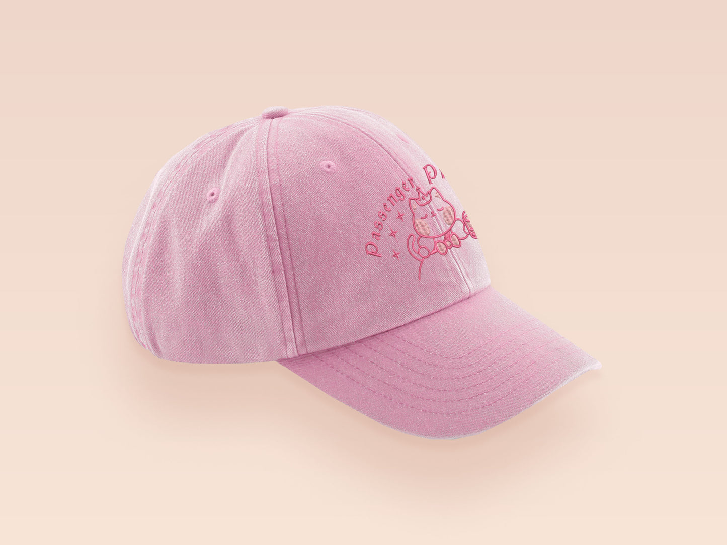 A vintage pink baseball cap hat with an embroidered cute princess cat wearing a seatbelt and holding a boba bubble tea drink with the quote Passenger Princess
