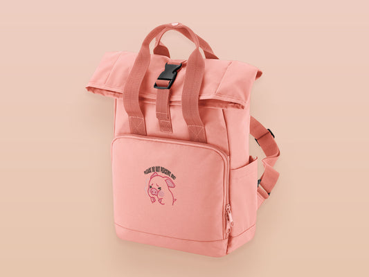 Pink roll top twin handle backpack with an embroided design of cute crying pig and the quote please do not percive me