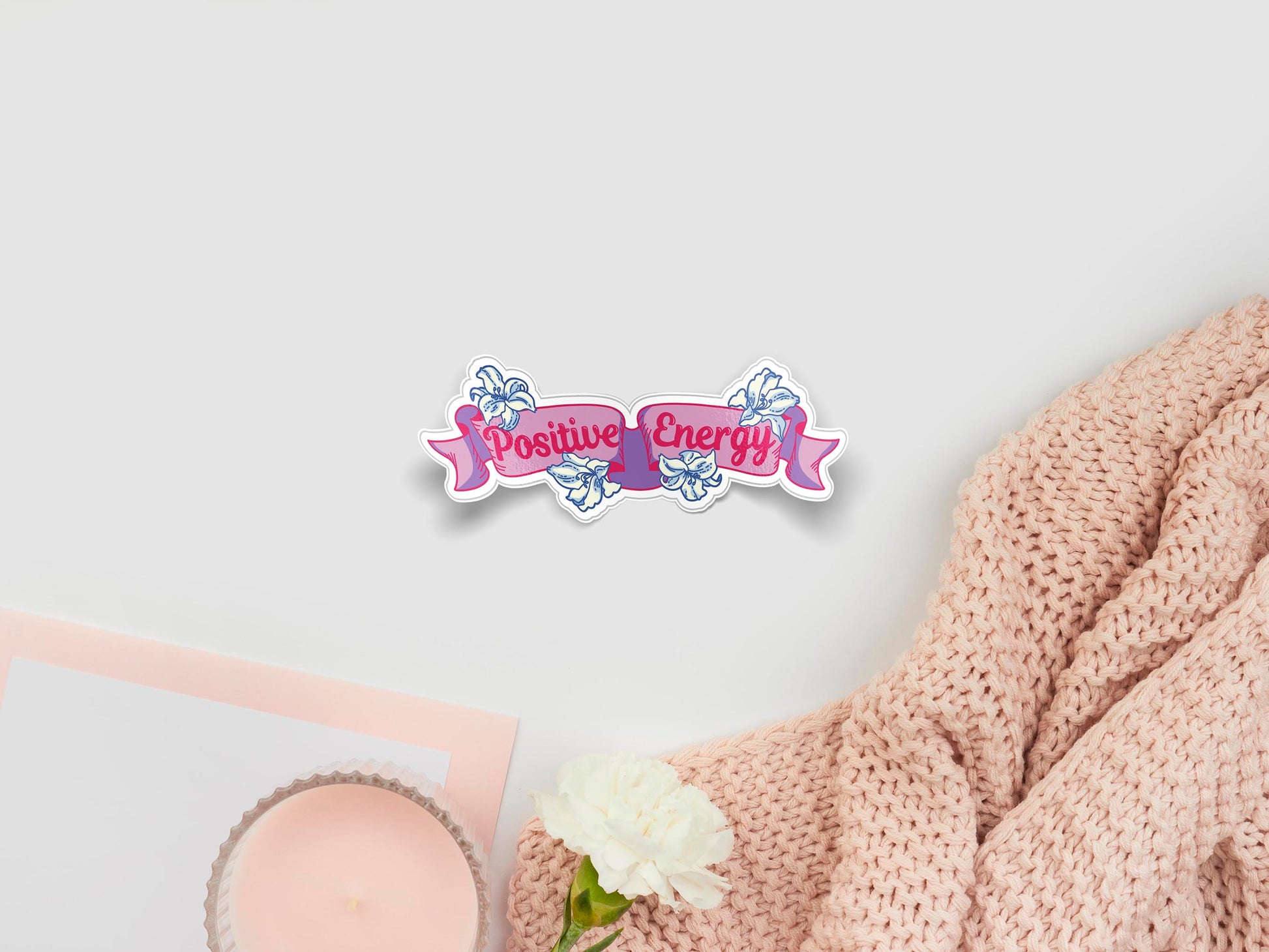 Large sticker of digital illustration cartoon of a purple ribbon with pink text that reads Positive Energy, surrounded by white lily flowers