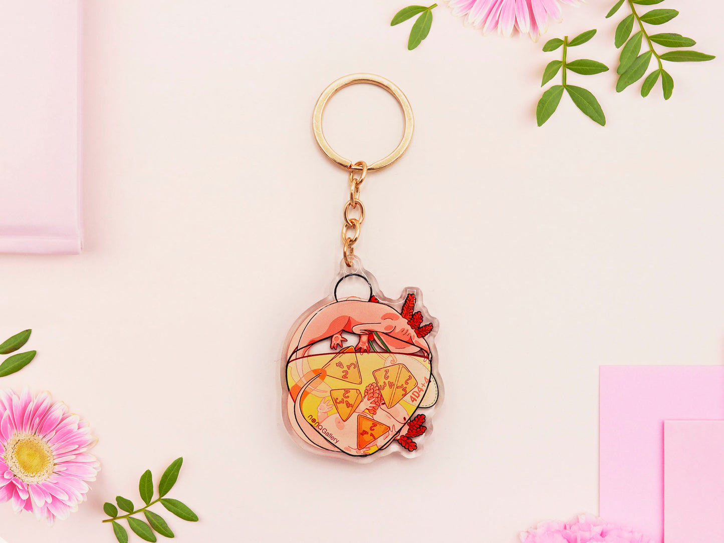Clear acrylic double sided gold clasp keychain with a cartoon illustrated design of two pink axolotls on a potion bottle labelled health +hp and with a yellow liquid and four orange d4 dice inside.