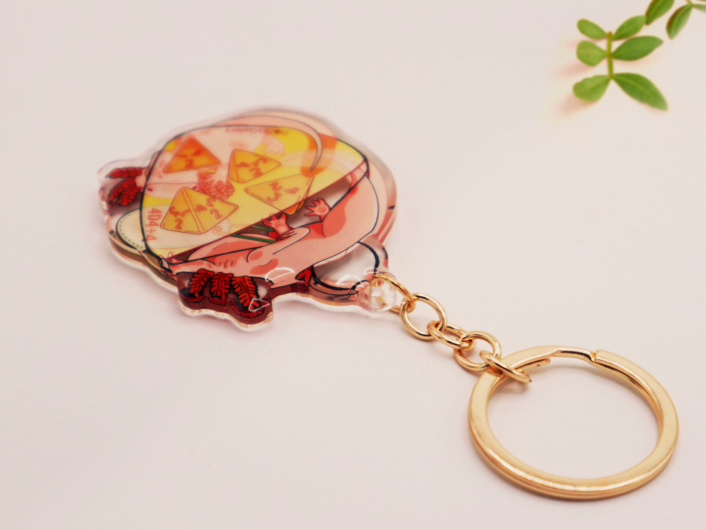 Clear acrylic double sided gold clasp keychain with a cartoon illustrated design of two pink axolotls on a potion bottle labelled health +hp and with a yellow liquid and four orange d4 dice inside.