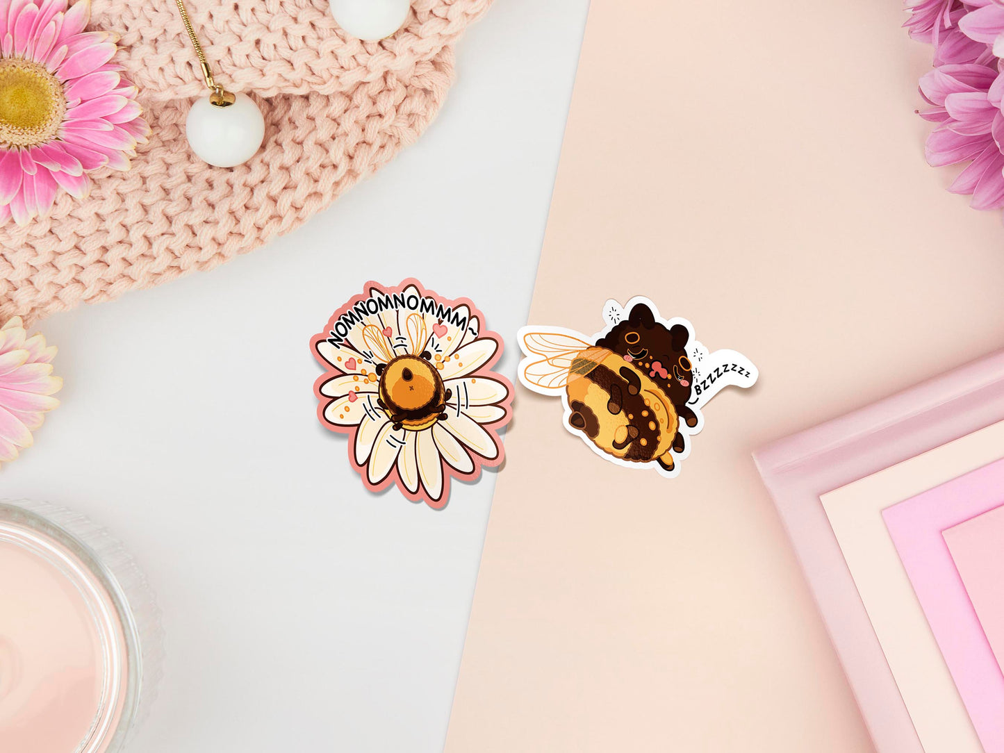 Two stickers of digital illustrated cartoon one is a flower with the bum of a bee sticking out with the word nomnomnomnomnom, the other is a sleeping bee covered in pollen with the word bzzzzzzz