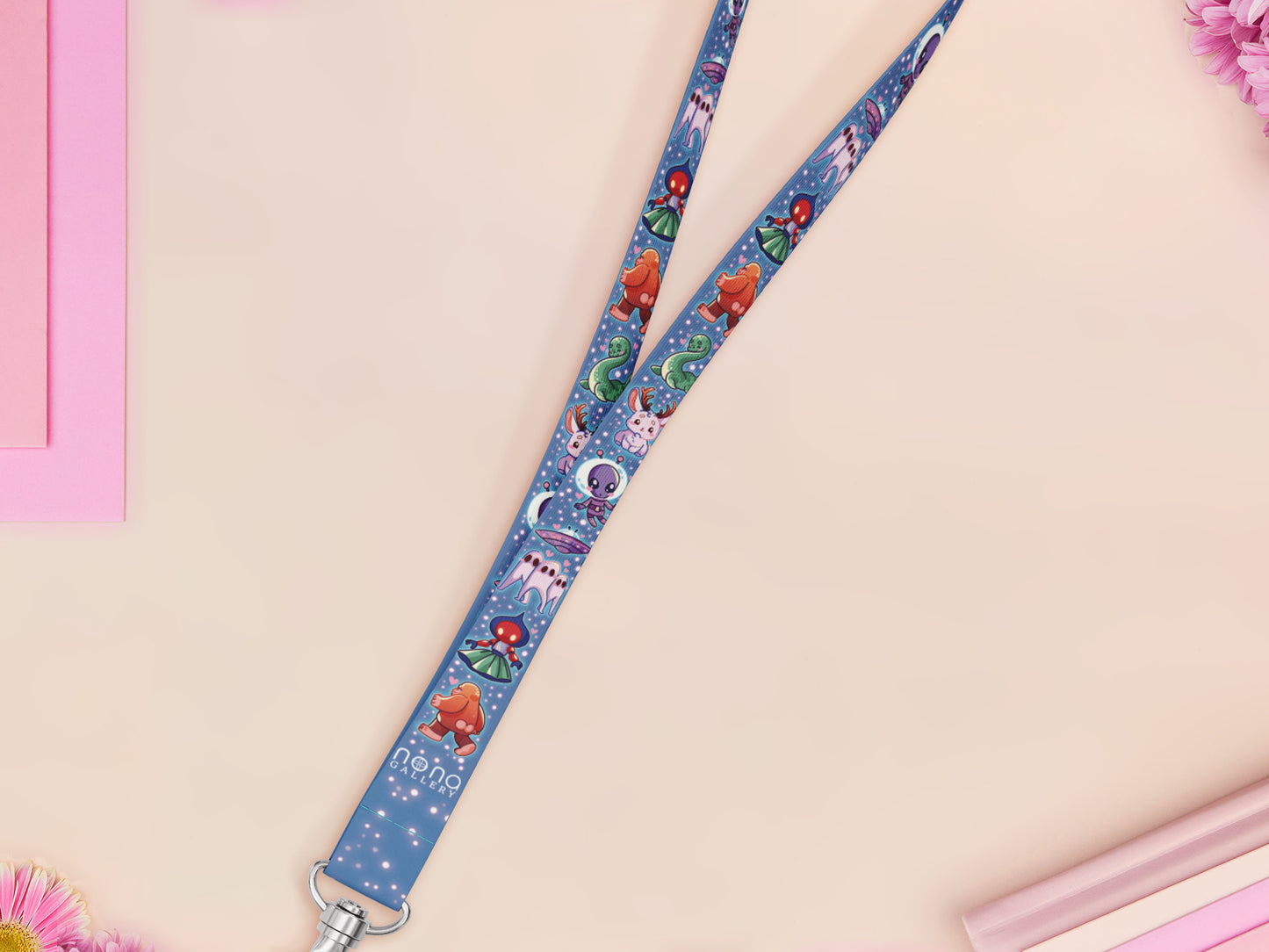 Cute full legth dark blue lanyard with a double sided cryptid monster and alien pattern and silver swivel hook clasp.