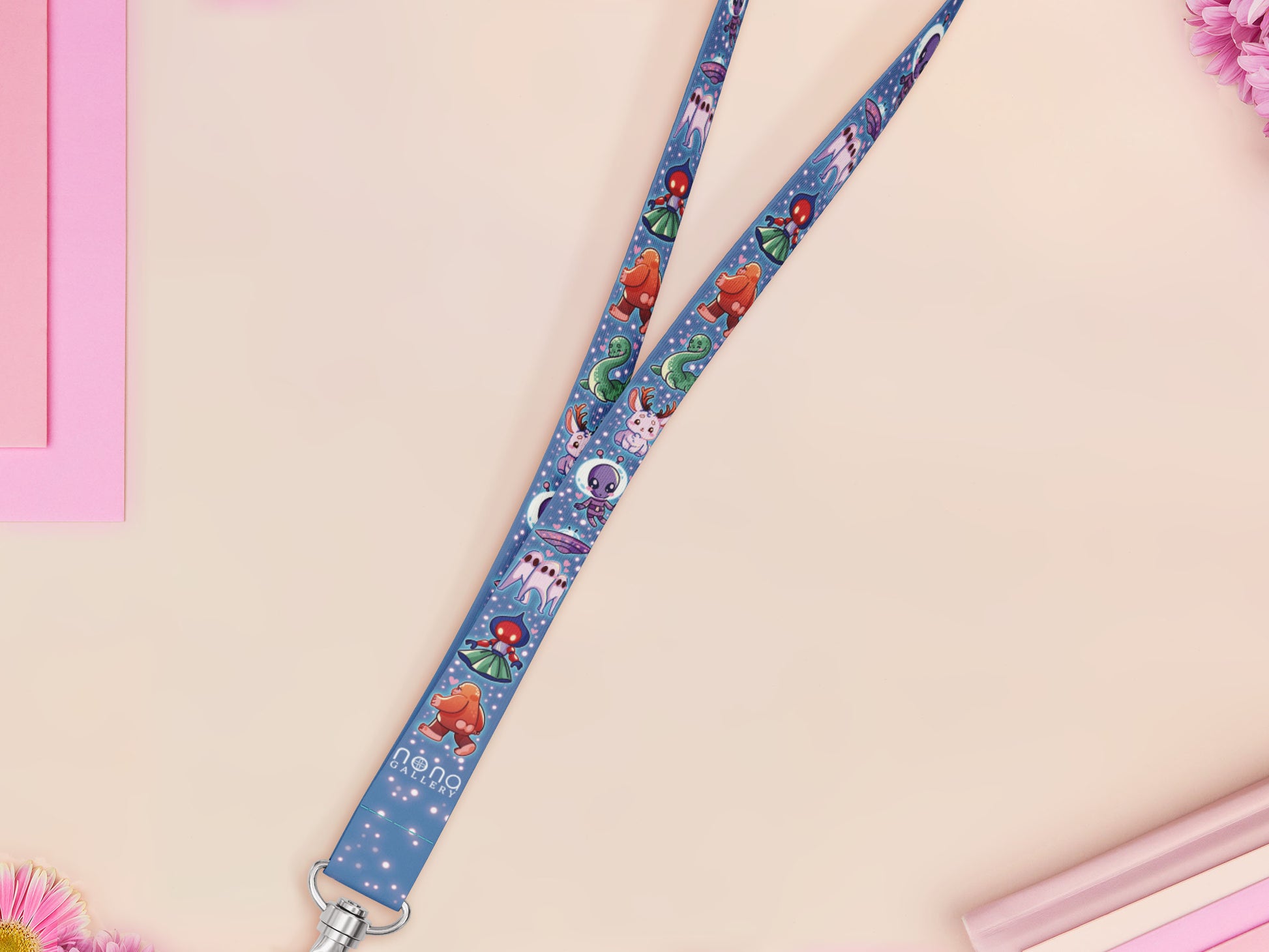 Cute full legth dark blue lanyard with a double sided cryptid monster and alien pattern and silver swivel hook clasp.