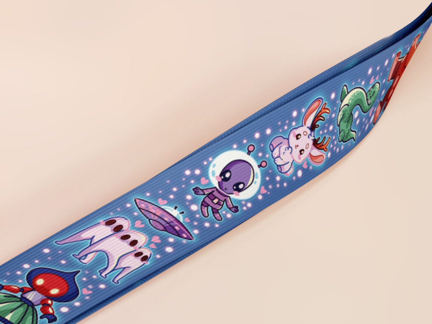 Cute full legth dark blue lanyard with a double sided cryptid monster and alien pattern and silver swivel hook clasp.