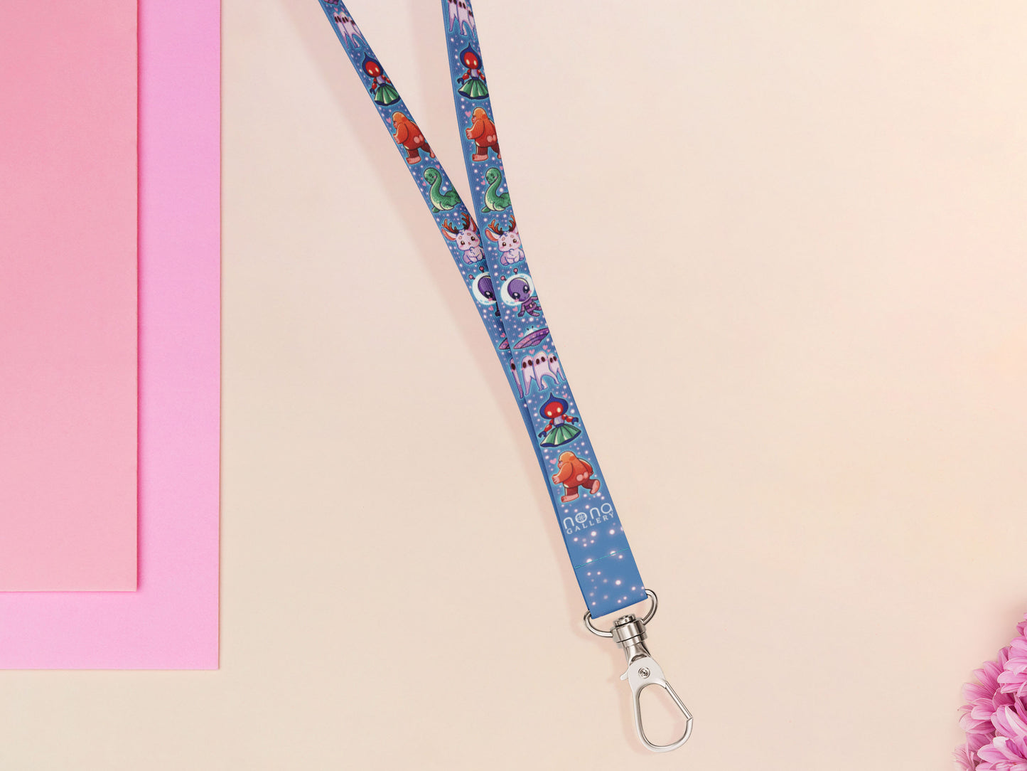 Cute full legth dark blue lanyard with a double sided cryptid monster and alien pattern and silver swivel hook clasp.