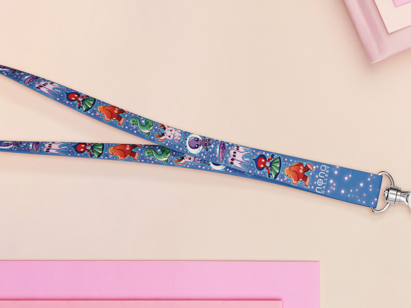 Cute full legth dark blue lanyard with a double sided cryptid monster and alien pattern and silver swivel hook clasp.