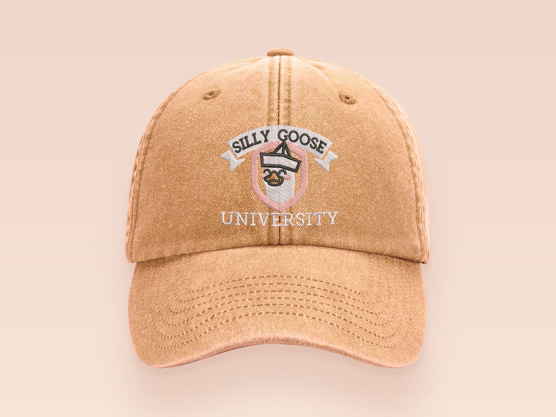 A vintage yellow baseball cap hat with an embroidered cute goose wearing a paper hat with the quote Silly Goose University