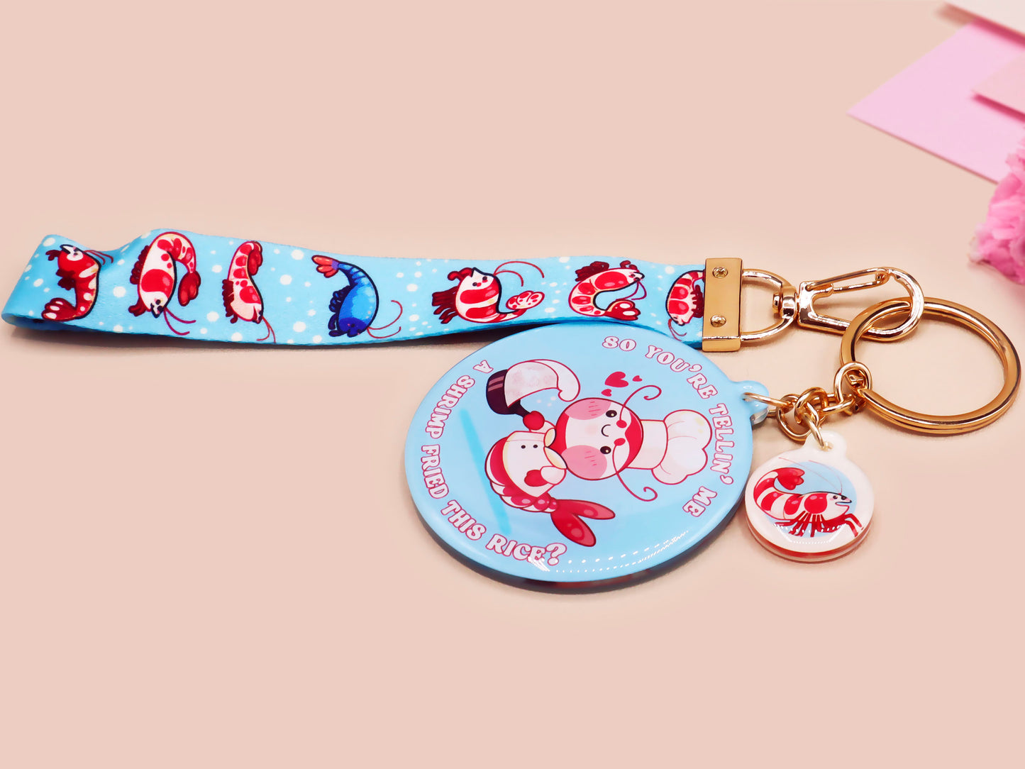 Acrylic epoxy shrimp keychain with a large acrylic charm of a a chef shrimp frying rice in a pan with the quote so you're telling me a shrimp fried this rice, a smaller charm of a cute baby shrimp and a matching blue shrimp lanyard.