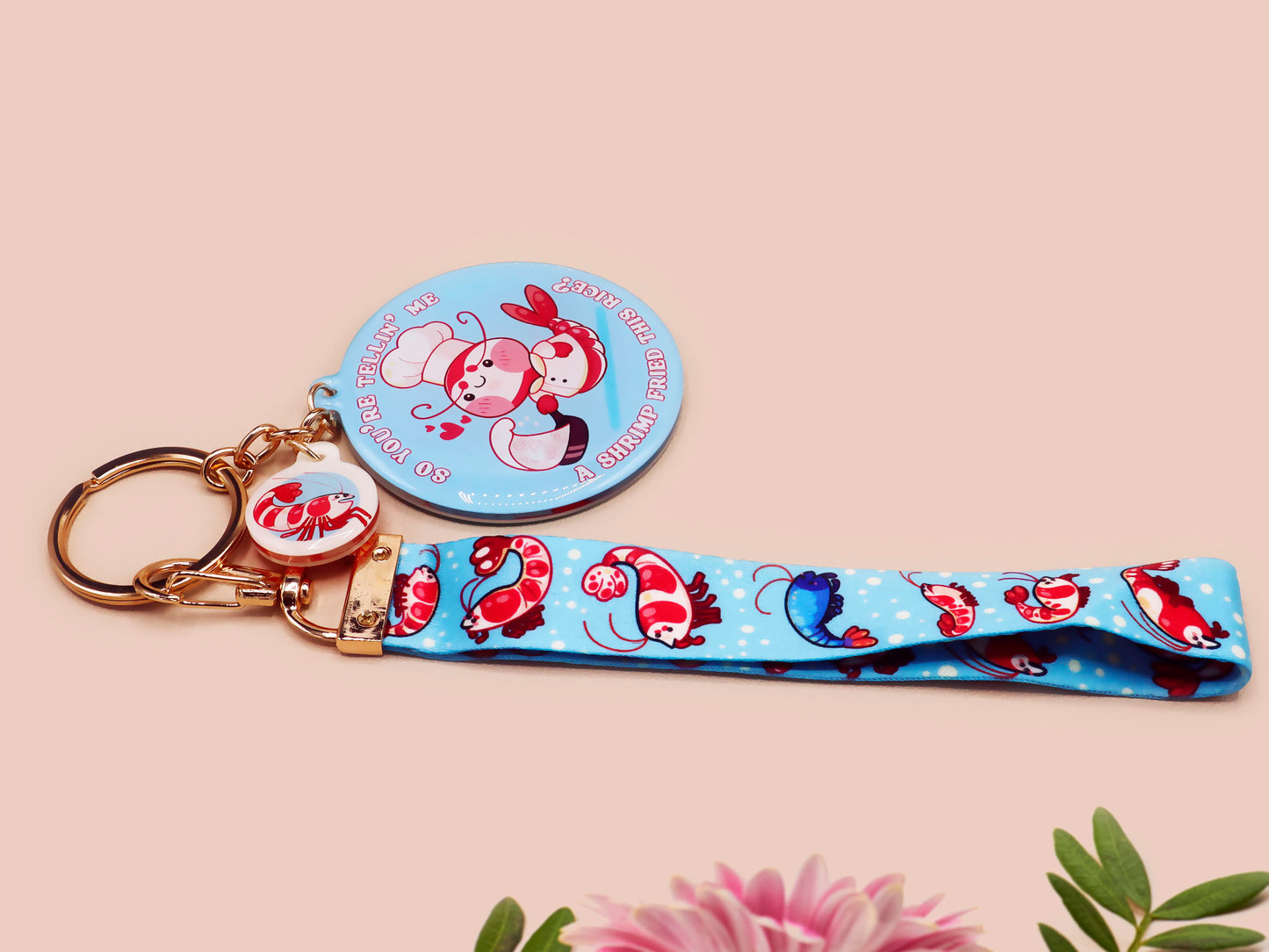 Acrylic epoxy shrimp keychain with a large acrylic charm of a a chef shrimp frying rice in a pan with the quote so you're telling me a shrimp fried this rice, a smaller charm of a cute baby shrimp and a matching blue shrimp lanyard.