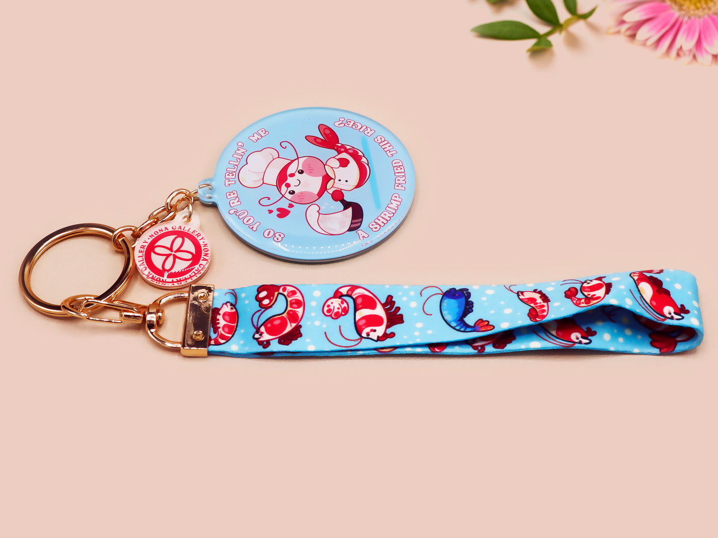 Acrylic epoxy shrimp keychain with a large acrylic charm of a a chef shrimp frying rice in a pan with the quote so you're telling me a shrimp fried this rice, a smaller charm of a cute baby shrimp and a matching blue shrimp lanyard.