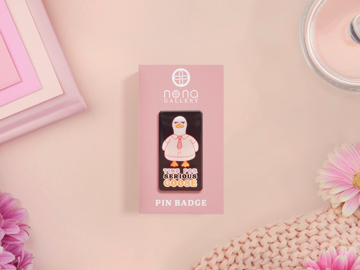 A black acrylic pin badge with a pink heart-shaped pin back clasp. The design of the pin badge is of a cute goose in a shirt and tie with the quote Time For Serious Goose