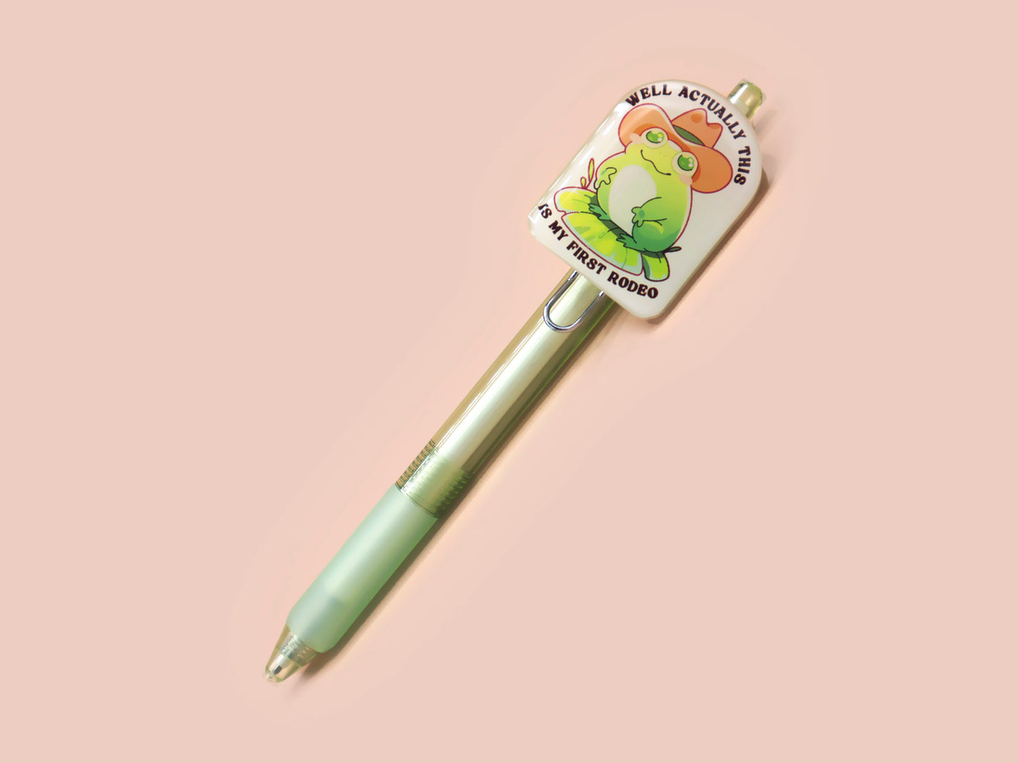 Green ballpoint pen with black ink and a cute chibi cowboy frog design.