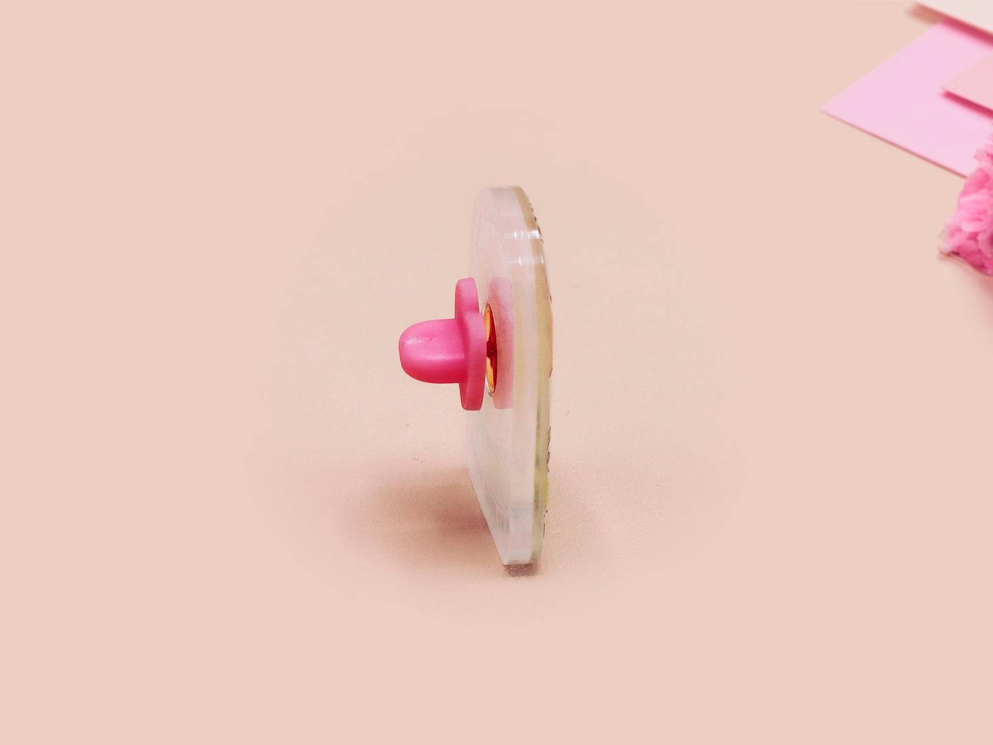 Clear acrylic pin badge with a pink heart-shaped rubber pin back clasp. The design of the pin badge is a cute chibi frog wearing a cowboy hat stetson and the quote well actually this is my first rodeo.