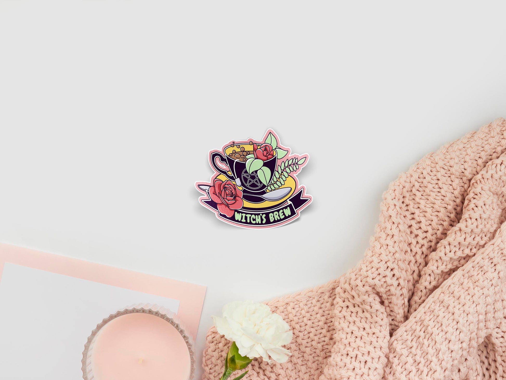 Large sticker of digital illustration cartoon of a dark purple and yellow cup and saucer with a pentagram design, filled with bubbling brown liquid and red roses, with a ribbon underneath with the quote Witch's Brew