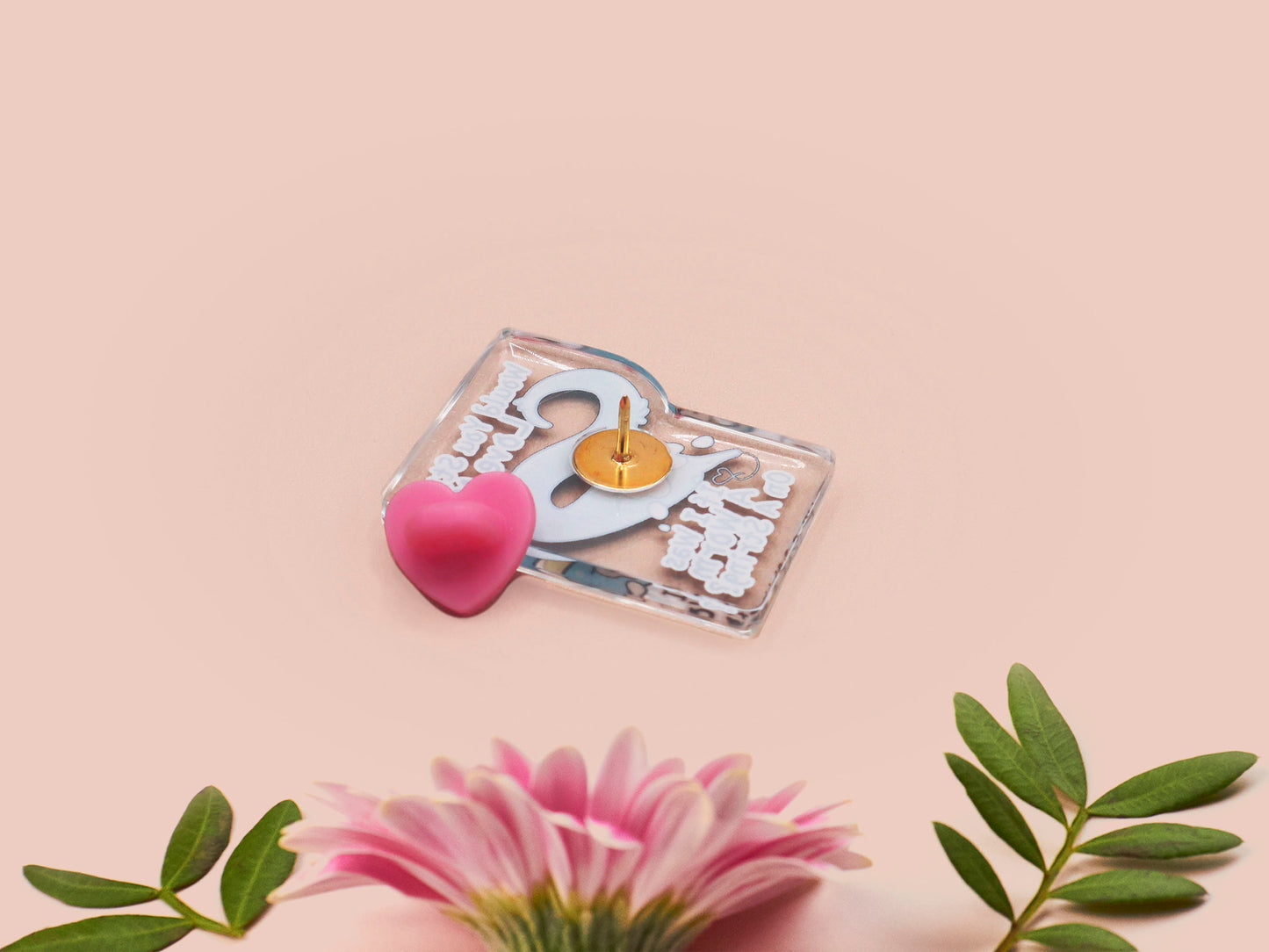 A clear acrylic pin badge with a pink heart-shaped rubber pin back clasp. The pin badge has a design of a cute blue crying worm on a string with the quote would you still love me if I was a worm on a string?