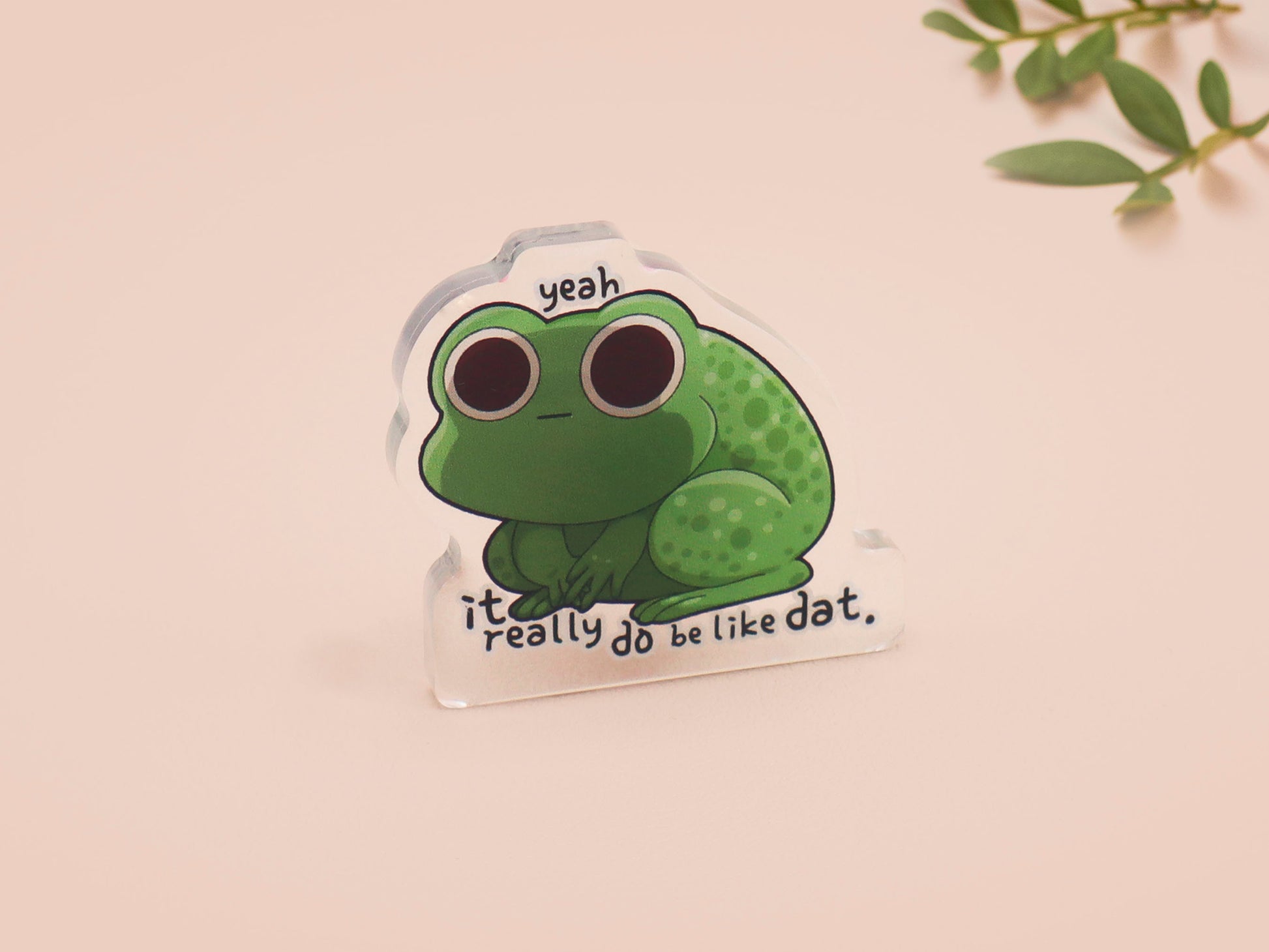 Clear acrylic pin badge with a pink heart-shaped rubber pin back clasp. The design of the pin badge is a cute cartoon stressed frog with the quote yeah it really do be like dat.