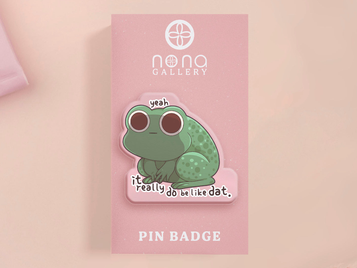 Clear acrylic pin badge with a pink heart-shaped rubber pin back clasp. The design of the pin badge is a cute cartoon stressed frog with the quote yeah it really do be like dat.