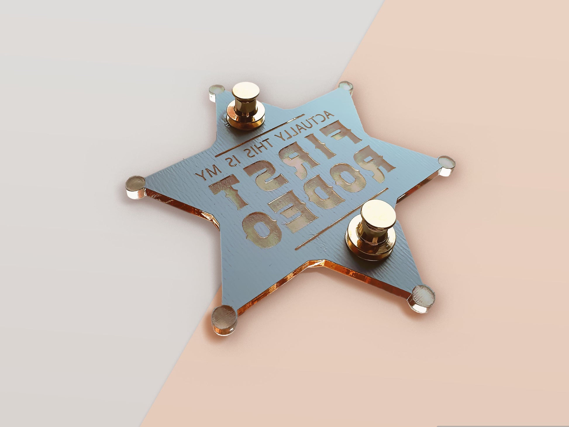 The back of a mirror gold laser engraved acrylic sherriff badge with the funny quote actually this is my first rodeo, with two gold locking pin back clasps.