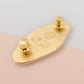 The back of the gold Enamel Talisman Pin showing the branding and logo of Nona Gallery as well as two gold locking pin backs.