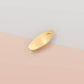 The back of the mini talisman charm showing a smooth gold finish with small loop hole.