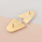 The back of the two interlocking gold Enamel Talisman Pins showing the branding and logo of Nona Gallery as well as two gold pin clasp backs.