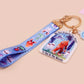 Acrylic epoxy cryptid and alien keychain with a large acrylic charm of a bigfoot yeti nightcrawlers and an alien in a UFO with the quote Be The Cryptidy You Want To See In the Woods, a smaller charm of the flatwood monster and a matching lanyard.