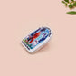Clear acrylic pin badge with pink heart-shaped rubber pin back clasp. The design of the pin badge is a cute cartoon chibi fresno nightcrawlers, yeti bigfoot and alien UFO in a forest with the quote Be The Cryptid You Want To See In The Woods.