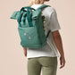 Green roll top twin handle backpack with an embroided design of cute space alien cat floating in the stars and the quote beam me up I want to leave!