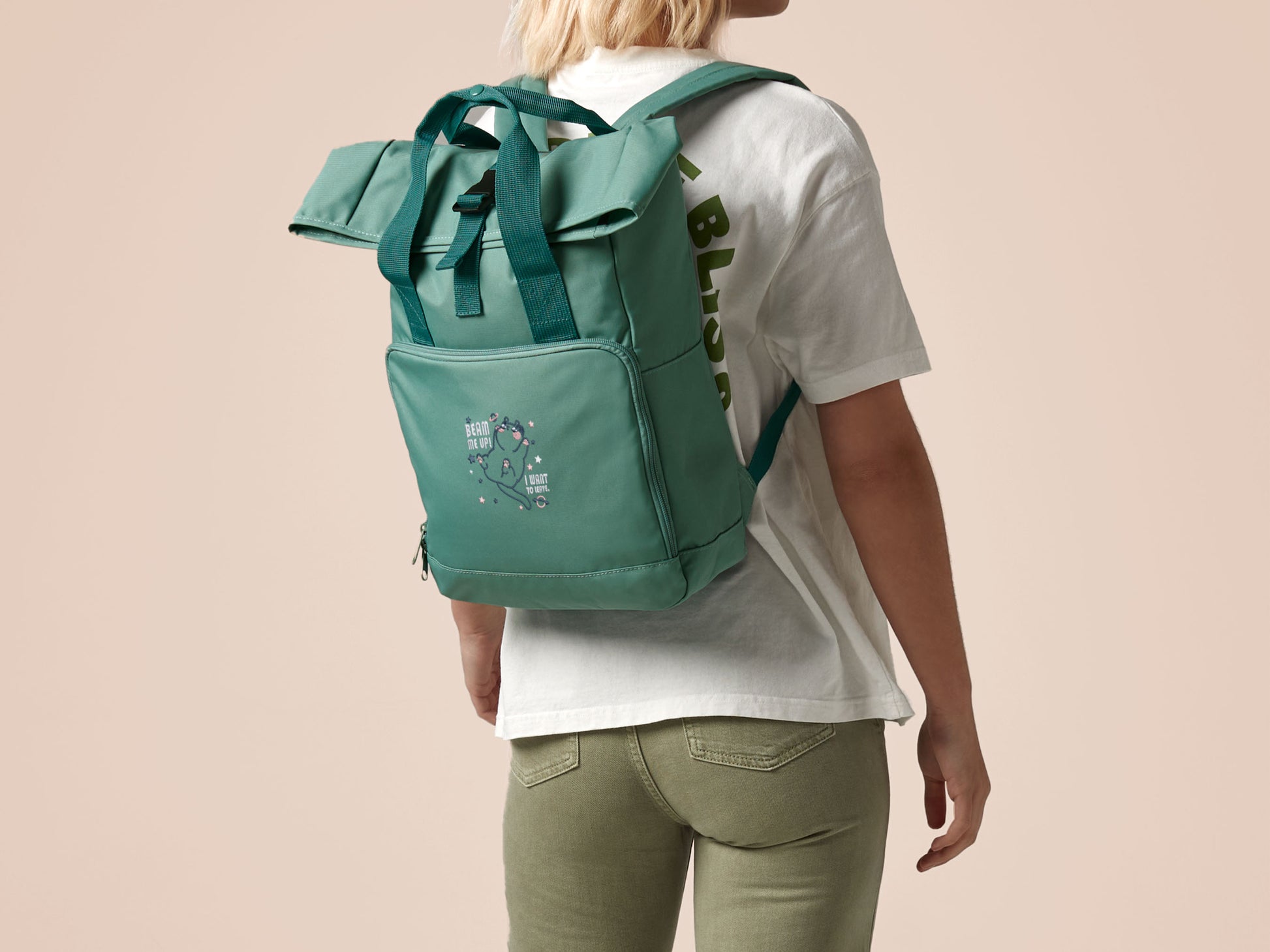 Green roll top twin handle backpack with an embroided design of cute space alien cat floating in the stars and the quote beam me up I want to leave!