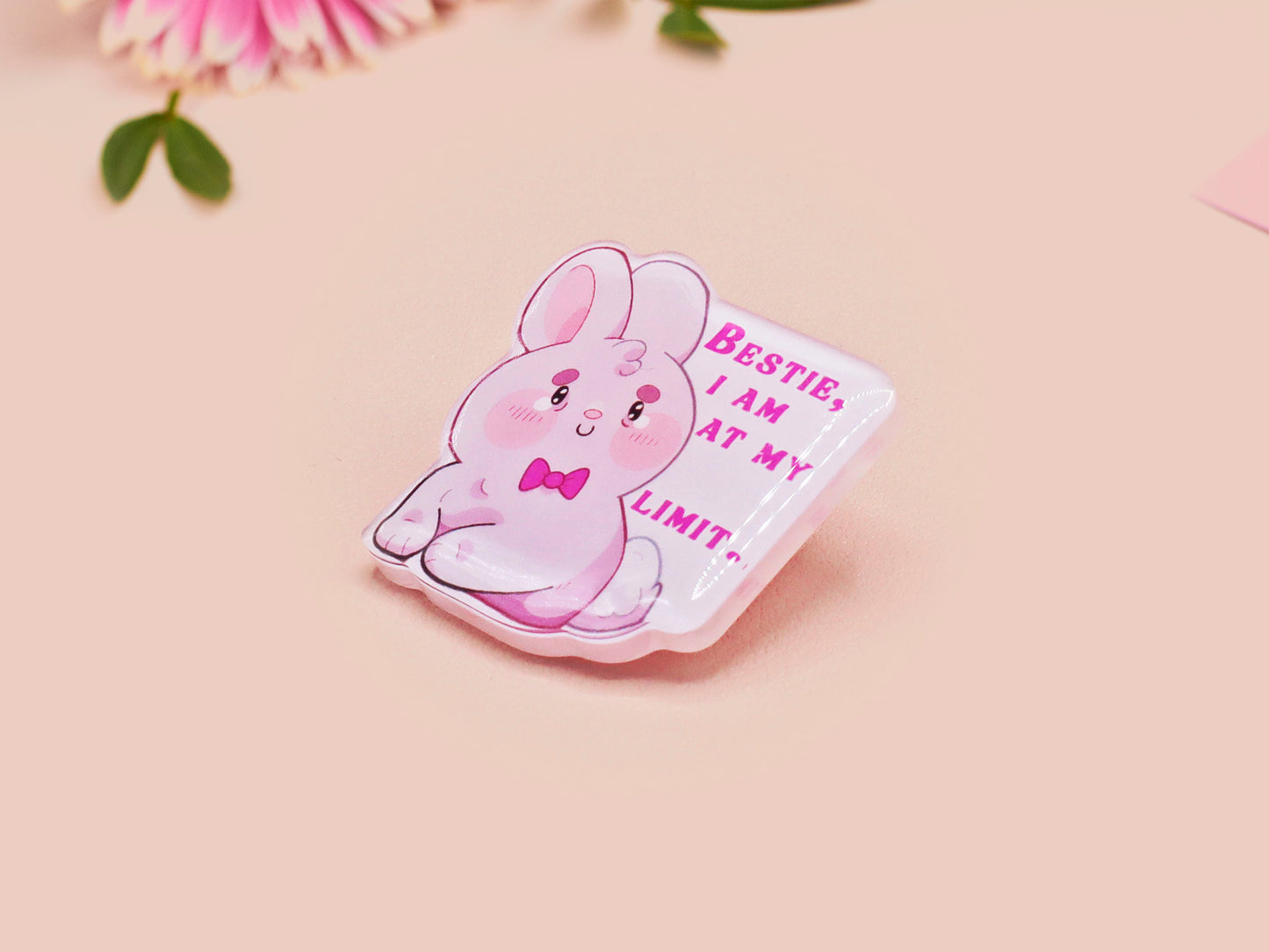 A cute transparent acrylic pin badge with a pink heart-shaped rubber clasp pin back of a chibi bunny rabbit crying with the text Bestie I am at my limit