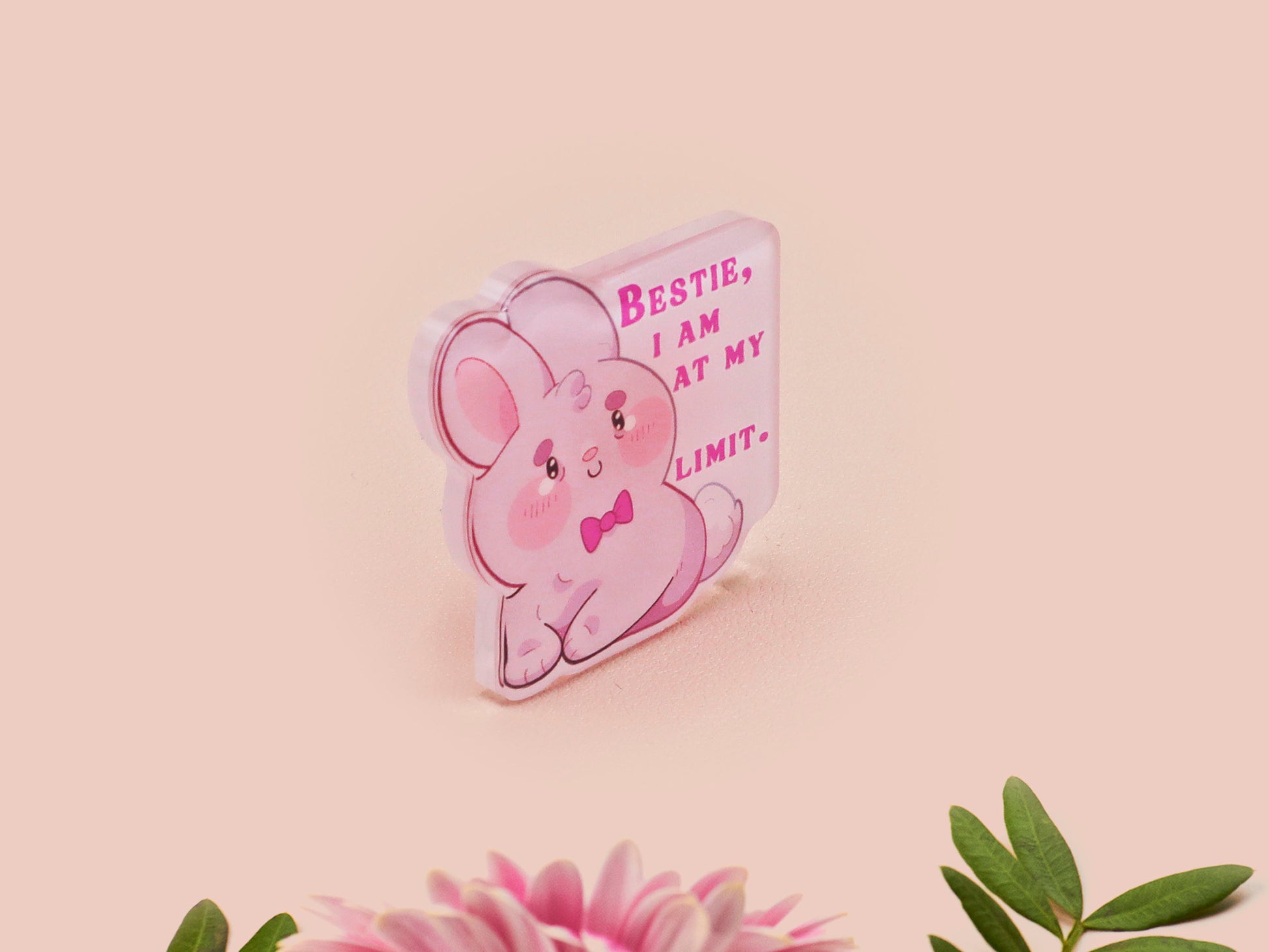 A cute transparent acrylic pin badge with a pink heart-shaped rubber clasp pin back of a chibi bunny rabbit crying with the text Bestie I am at my limit