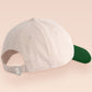 Vintage contrast cream and green peek baseball cap with an embroidered design of a cartoon bird and the quote bird brain.