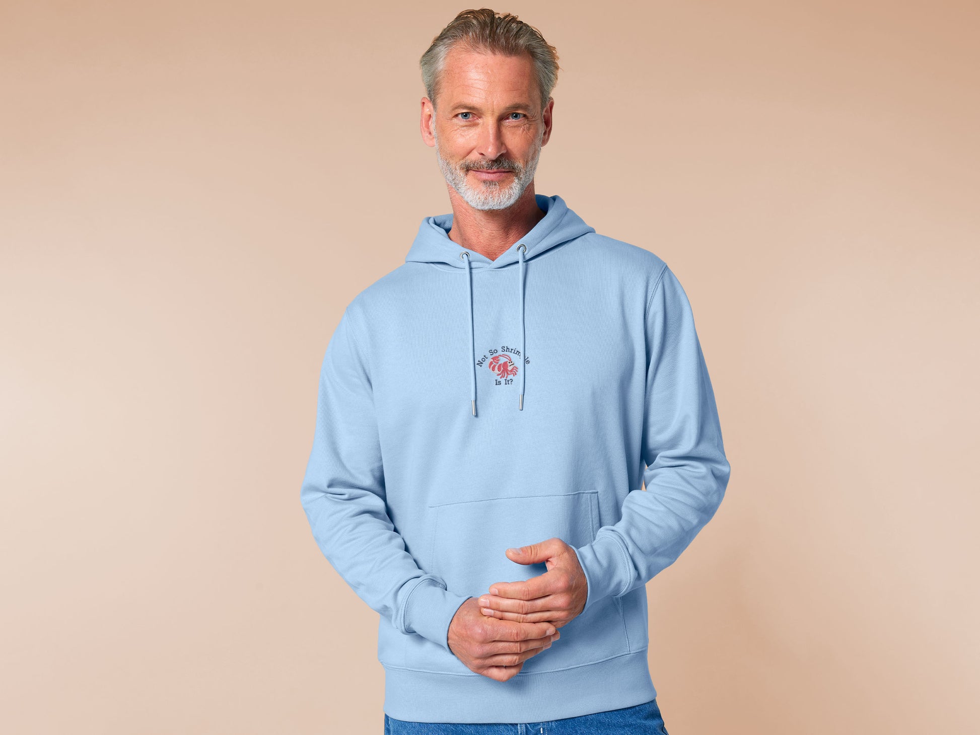 A blue long sleeve hoodie, with an embroidered chibi shrimp looking concerned and the quote Not so shrimple is it?