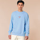A blue long sleeve sweater, with an embroidered chibi shrimp looking concerned and the quote Not so shrimple is it?