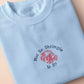 A blue short sleeve tshirt, with an embroidered chibi shrimp looking concerned and the quote Not so shrimple is it?