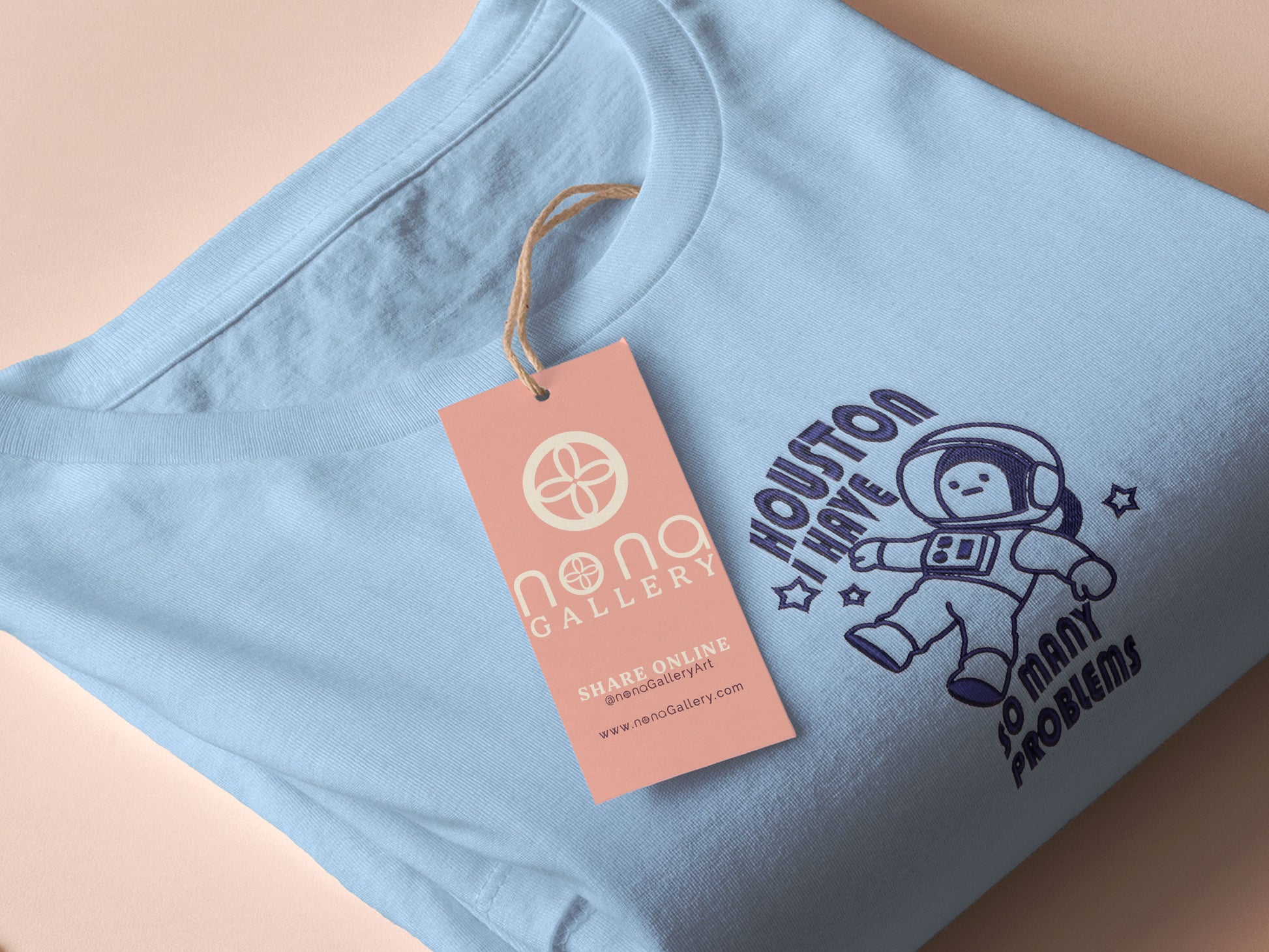 T-shirt with an embroidered blue design of a cute chibi astronaut surrounded by the funny quote Houston I have so many problems