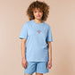 A blue short sleeve tshirt, with an embroidered chibi shrimp looking concerned and the quote Not so shrimple is it?