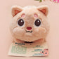 An adorable fluffy cat plushie toy with cute embroidered eyes, facial expression and applique stripes and pawprint toe beans, with a hang tag describing the cat as Brenda.