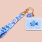 Acrylic epoxy underwater fish keychain with a large acrylic charm of a blue fish with the quote buy a man eat fish he day teach fish man to a lifetime, a smaller charm of a cute fish and a matching underwater lanyard.