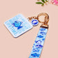 Acrylic epoxy underwater fish keychain with a large acrylic charm of a blue fish with the quote buy a man eat fish he day teach fish man to a lifetime, a smaller charm of a cute fish and a matching underwater lanyard.