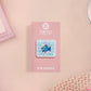 A clear acrylic pin badge with a pink heart-shaped pin back clasp. The design of the pin badge is of a cute chibi blue fish with the quote buy a man eat fish he day teach fish man to a lifetime.