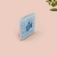 A clear acrylic pin badge with a pink heart-shaped pin back clasp. The design of the pin badge is of a cute chibi blue fish with the quote buy a man eat fish he day teach fish man to a lifetime.