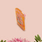 A yellow acrylic pin badge with a pink heart-shaped pin back clasp. The design of the pin badge is of a cute mouse napping in bed with a patchwork quilt with the quote can't mistakey if not awakey.