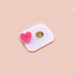 A yellow acrylic pin badge with a pink heart-shaped pin back clasp. The design of the pin badge is of a cute mouse napping in bed with a patchwork quilt with the quote can't mistakey if not awakey.