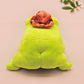 An adorable green frog plushie toy with cute embroidered eyes and facial expression, wearing a cowboy hat with a brown ribbon, and a hang tag describing the frog as Carl.